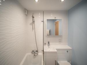 bagno bianco con doccia e lavandino di Stunning 2 bed seaside apartment with Sea Views a Bournemouth