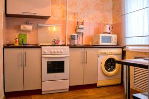 a kitchen with a washing machine and a microwave at Есения in Petropavlovsk