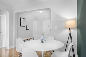 uma sala de jantar branca com uma mesa e cadeiras brancas em Warm and Comfortable 3 BR em Nova York