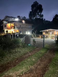 a house with a fence in front of it at night at Moonlight Chillers By LexStays in Yedapalli