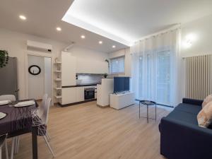 ein Wohnzimmer mit einem blauen Sofa und einer Küche in der Unterkunft [IHost Apartment] - Rogoredo 27 in Mailand