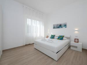 ein weißes Schlafzimmer mit einem großen weißen Bett und einem Tisch in der Unterkunft [IHost Apartment] - Rogoredo 27 in Mailand