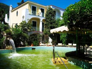 a swimming pool with a fountain in front of a building at Villa Ciccio in Ischia Town