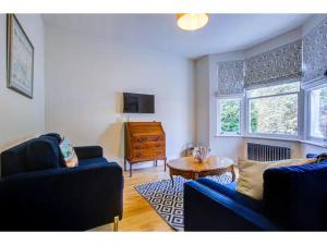 ein Wohnzimmer mit 2 blauen Sofas und einem Tisch in der Unterkunft Pass the Keys Stunning house in Leigh in Southend-on-Sea