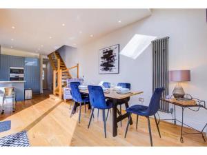 uma sala de jantar com uma mesa e cadeiras azuis em Pass the Keys Stunning house in Leigh em Southend-on-Sea
