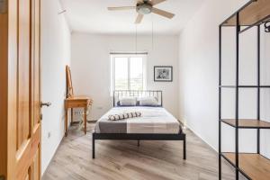 - une chambre avec un lit et un ventilateur de plafond dans l'établissement Gozo Escape 2-Bed Apartment in Marsalforn, à Marsalforn