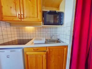 una pequeña cocina con fregadero y microondas en Appartement Les Saisies, 2 pièces, 4 personnes - FR-1-594-222, en Hauteluce