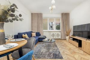 a living room with a blue couch and a tv at Beautiful One Bedroom Apartment Zamkowa by Rent like home in Gdańsk