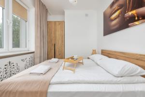 a bedroom with a large bed with a table on it at Beautiful One Bedroom Apartment Zamkowa by Rent like home in Gdańsk
