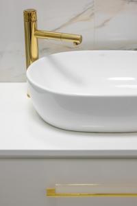 a white sink with a gold faucet on a counter at Beautiful One Bedroom Apartment Zamkowa by Rent like home in Gdańsk