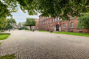 a cobblestone street in front of a brick building at Beautiful One Bedroom Apartment Zamkowa by Rent like home in Gdańsk