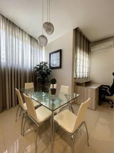 a dining room with a glass table and chairs at Swieqi : Central 3-Bed Apartment in Is-Swieqi