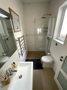a white bathroom with a sink and a toilet at Swieqi : Central 3-Bed Apartment in Is-Swieqi