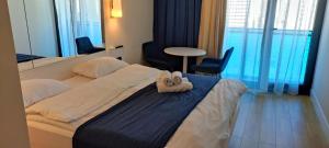 une chambre d'hôtel avec un lit avec une serviette dessus dans l'établissement Orbi City Blok D, à Batoumi