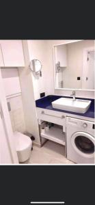une salle de bain avec toilettes et lavabo et une machine à laver dans l'établissement Orbi City Blok D, à Batoumi
