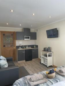 a kitchen and a living room with a couch and a kitchen at Wrens nest in Newton Stewart