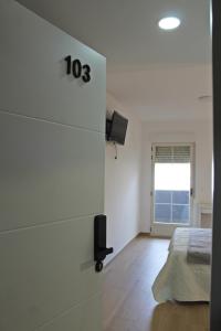 a white bedroom with a bed and a window at La familia in Santa Ana (Urb. Riachuelos 2)