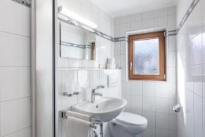 La salle de bains blanche est pourvue d'un lavabo et de toilettes. dans l'établissement Haus Fender, à Sölden