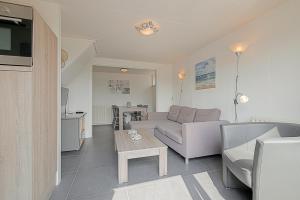 sala de estar con sofá y mesa en Vakantiehuis Beach Life - Callantsoog, en Callantsoog