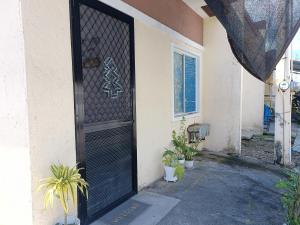 uma porta preta de uma casa com plantas ao lado em Amigas Lodge Transient em San Felix
