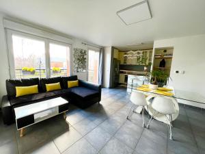 a living room with a black couch and a table at Design Apartment Disneyland Paris in Chessy