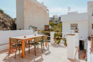 un patio con mesa de madera y sillas en Spacious home with lovely garden - TCM en Rincón de la Victoria