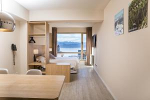 a hotel room with a bed and a view of the water at MINI LOFT Departamentos Bariloche in San Carlos de Bariloche +147 photos