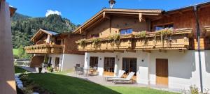 Hochalmbahnen Chalets Rauris 1-19, Maislaufeldweg 1s في راوريس: بيت فيه بلكونه عليه كراسي