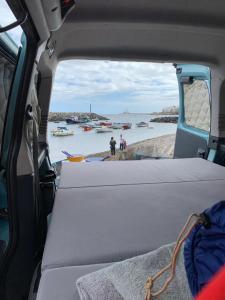 a view from the back of a van looking out at the water at CamperTF - old but lovable mini caravans in Tenerife in El Médano