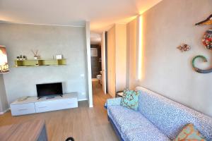 a living room with a blue couch and a television at Leonardo Walsh Apartment With Lake View in Albisano