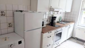 una cucina con elettrodomestici bianchi e frigorifero bianco di Nice Apartment in Apolda a Apolda