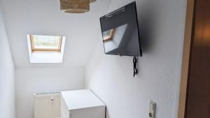 a bathroom with a toilet and a television on the wall at Nice Apartment in Apolda in Apolda
