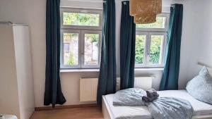 una camera da letto con tende blu e un letto e due finestre di Nice Apartment in Apolda a Apolda