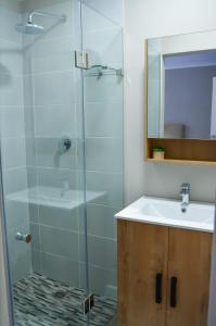 ein Bad mit einer Glasdusche und einem Waschbecken in der Unterkunft Ocean Pearl Hermanus - 5 Bedrooms in Hermanus