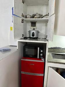 una pequeña cocina con microondas y nevera roja en Cebu City Studio Condo Unit-WIFI-A/C-Hot Shower-(U302) en Cebú
