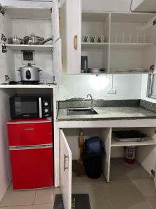 a small kitchen with a red refrigerator and a sink at Cebu City Studio Condo Unit-WIFI-A/C-Hot Shower-(U302) in Cebu City