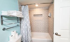 Un baño con ducha, bañera y WC. en Sunkissed-Modern Oceanfront Condo Daytona Beach, en Daytona Beach