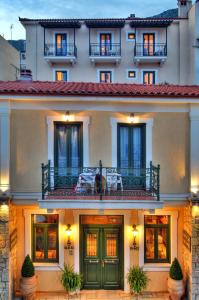 ein Gebäude mit einer grünen Tür und einem Balkon in der Unterkunft Artemis Hotel in Delphi