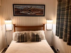 a bedroom with a bed with two lamps on it at Stringy Rocks in Morenish