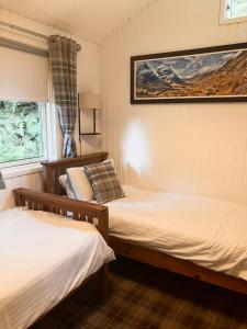 a bedroom with two beds and a picture on the wall at Stringy Rocks in Morenish
