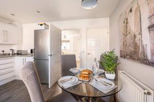 a kitchen with a table with plates of food on it at Entire Home in Swansea, near Swansea.dotcom Stadium, Sleeps 4, by Properties by O & G in Bon-y-maen