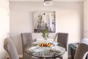 a dining room with a glass table and chairs at Entire Home in Swansea, near Swansea.dotcom Stadium, Sleeps 4, by Properties by O & G in Bon-y-maen