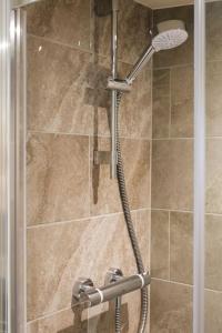 a shower with a shower head in a bathroom at The Garden Room in Knighton