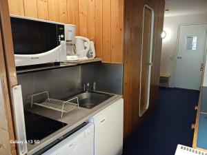 a kitchen with a sink and a microwave at Studio Les Arcs 1800, 1 pièce, 4 personnes - FR-1-411-426 in Arc 1800