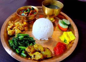 un plato de comida con arroz y verduras en una mesa en Naman Boutique Home, en Pokhara