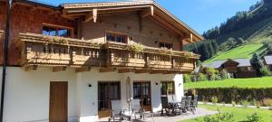 劳里斯Hochalmbahnen Chalets Rauris 1-18, Maislaufeldweg 1t的房屋设有带桌椅的阳台