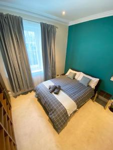 a bedroom with a bed and a blue wall at 3-Bed Flat Central London, 6 Min Walk from King's Cross Station in London