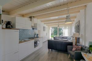 eine Küche und ein Wohnzimmer mit einem Sofa in der Unterkunft Vakantiehuis Heideblick - car-free park - Callantsoog in Callantsoog