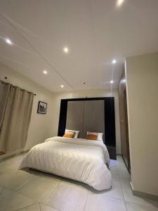 a bedroom with a large white bed in a room at AlanVal Apartments in Accra