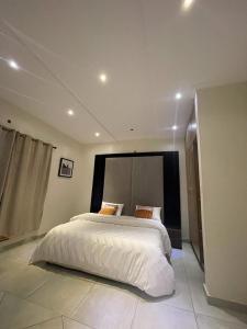 Un dormitorio con una gran cama blanca en una habitación. en AlanVal Apartments, en Accra 17 fotos más